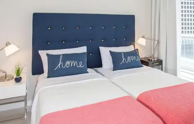 a bedroom with a blue headboard and two beds at MVR - High-Floor Luxury with Iconic Views in Miami