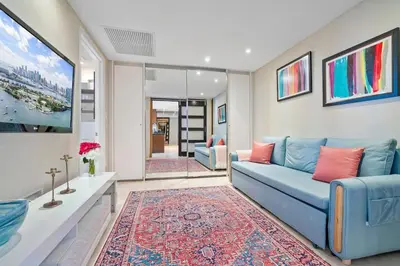 a living room with a blue couch and a rug at MVR - Designer Stay in Sky-High Tower in Miami