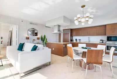 a living room and kitchen with a white couch and a table at MVR - Luxury Tower Stay with Miami Views in Miami