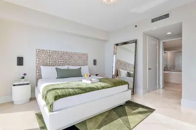 a white bedroom with a large bed and a bathroom at MVR - Luxury Tower Stay with Miami Views in Miami