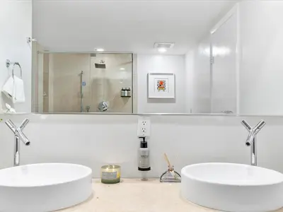 a white bathroom with two sinks and a mirror at MVR - Bay & City Views from the 45th in Miami
