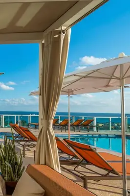 a pool with chairs and umbrellas next to the ocean at MVR-The Stay You-ll Talk About All Year in Miami