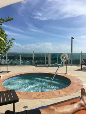 a man laying on a bench in a swimming pool at MVR - Grove-s Best Stay Near Everything You Want in Miami