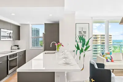 a white kitchen with a large white island in a room at MVR - Grove-s Best Stay Near Everything You Want in Miami