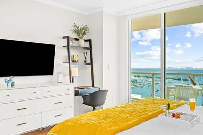 a bedroom with a bed with a television and a balcony at MVR - Steps from Miami-s Top Attractions in Miami