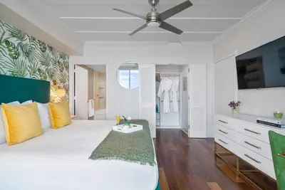 a bedroom with a white bed with a ceiling fan at MVR - Views You-ll Brag About for Years in Miami