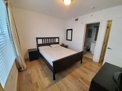 a bedroom with a bed and a wooden floor at 1 Bed on Collins Av close to Beach in Miami Beach