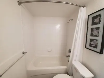 a white bathroom with a tub and a toilet at 1 Bed on Collins Av close to Beach in Miami Beach
