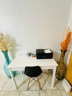 a white desk with a black briefcase on it next to vases at Miami Casa II in Miami Gardens