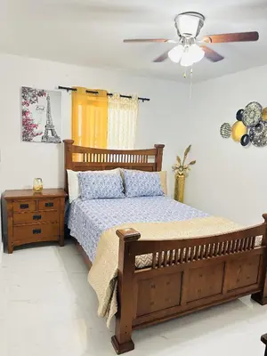 a bedroom with a wooden bed and a ceiling fan at Miami Casa II in Miami Gardens
