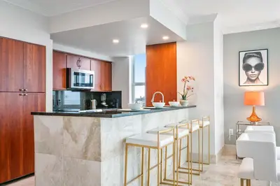 a kitchen with a bar with stools and a microwave at MVR - Where Families and Professionals Align in Miami