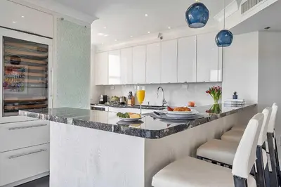 a kitchen with white cabinets and a granite counter top at MVR - Elevate Your Stay with Panoramic Bay Views in Miami