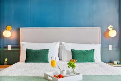 a bed with a tray of fruit and a glass of orange juice at MVR-See the City Sparkle-Every Night in Miami