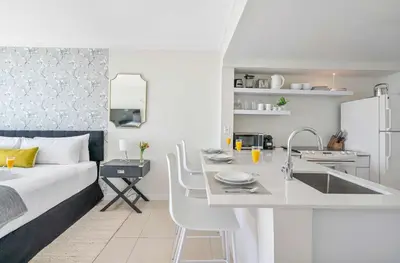 a bedroom with a bed and a kitchen with a sink at MVR-Your Gateway to Miami-s Culture & Calm in Miami