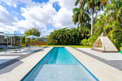 a swimming pool in a villa with palm trees at 4BR Biscayne River Home with Pool & Pickleball Fun in Biscayne Gardens