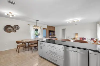 a kitchen and dining room with a table and chairs at 4BR Biscayne River Home with Pool & Pickleball Fun in Biscayne Gardens