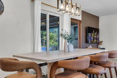 a dining room with a large wooden table and chairs at 4BR Biscayne River Home with Pool & Pickleball Fun in Biscayne Gardens