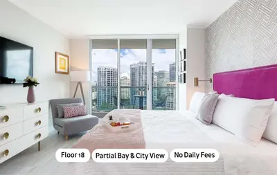 a bedroom with a bed and a chair and a window at MVR - Experience Life Above the Miami Skyline in Miami