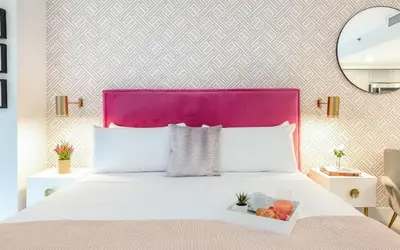 a white bed with a purple headboard and a tray of fruit at MVR - Experience Life Above the Miami Skyline in Miami
