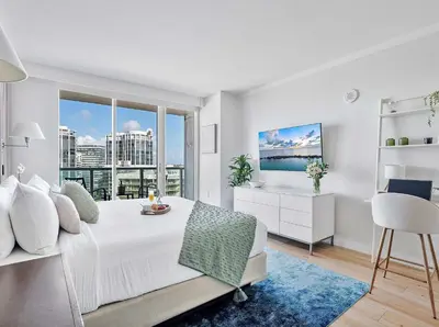 a bedroom with a white bed and a large window at MVR - Where Style Comfort and Convenience Meet in Miami
