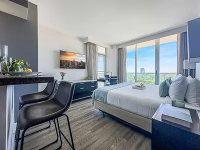 a hotel room with a bed and a desk with a chair at MVR - Miami Vibes from Your Balcony Retreat in Miami