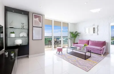 a living room with a pink couch and a table at MVR-Stop Searching-This Stay Has It All in Miami