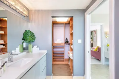 a bathroom with blue walls and a sink and a hallway at MVR-Stop Searching-This Stay Has It All in Miami