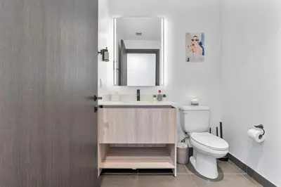 a bathroom with a sink and a toilet and a mirror at MVR - Walkable Downtown Gem with Breathtaking Views in Miami