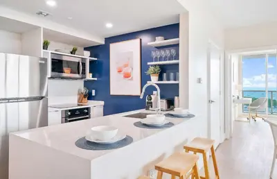 a kitchen with a white counter and blue walls at MVR - Stop Searching-This Grove Stay Has It All in Miami