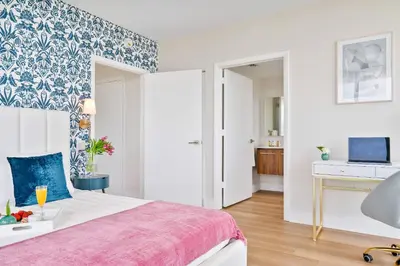 a bedroom with a bed with a blue and white wallpaper at MVR - Stop Searching-This Grove Stay Has It All in Miami