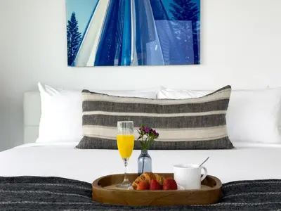 a tray of fruit and a glass of orange juice on a bed at MVR - Act Fast-Grove-s Best Stays Don-t Last in Miami