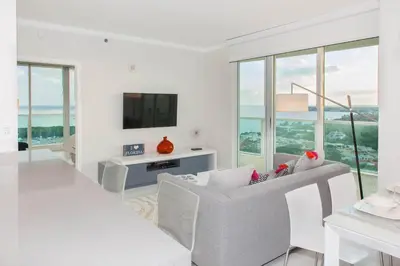 a white living room with white furniture and windows at MVR - Miami-s Most Exclusive Stay-Revealed in Miami