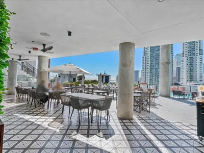 a patio with tables and chairs on a building at MVR - 5-Star Resort Pool & Private Balcony in Miami
