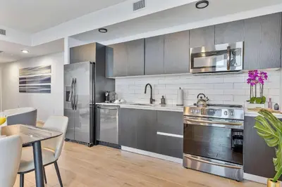 a kitchen with stainless steel appliances and a table at MVR - Designer Apt with Jaw-Dropping Views & Pool in Miami
