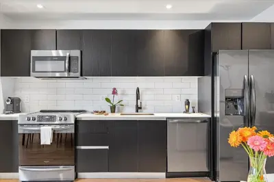 a kitchen with black cabinets and a stainless steel refrigerator at MVR - 5-Star Downtown Stay Near Miami-s Hotspots in Miami