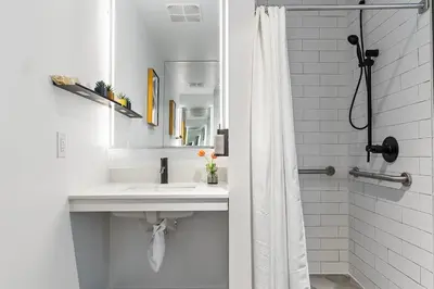 a white bathroom with a sink and a shower at MVR - VIP Pool Deck & Rooftop Lounge Access in Miami
