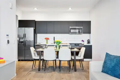 a kitchen with a table with white chairs and a refrigerator at MVR - Last-Minute Deal Luxe Stay in Downtown in Miami