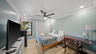 a bedroom with a bed and a flat screen tv at Luxury Queen Room, Free Car Service, Walk to UM! in Miami