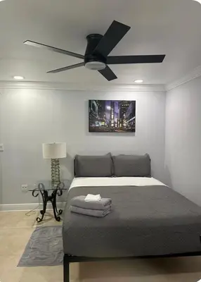 a bedroom with a bed with a ceiling fan at Large Private Room, Free Car Service, Walk to UM! in Miami