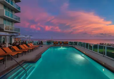 a swimming pool on the roof of a building with a sunset at MVR Suite with Picture-Perfect Views of Miami in Miami