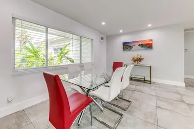a dining room with a glass table and red chairs at Outdoor Oasis with Games Sleek Hollywood Home! in Hollywood