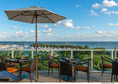a patio with tables and chairs and an umbrella at MVR Not a normal suite-An Elevated Miami Stay in Miami