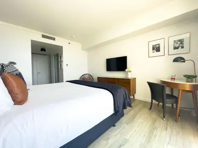 a bedroom with a bed and a desk with a television at MVR King Suite Room Bay View in Miami