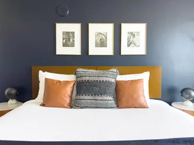a bedroom with a bed with pillows and pictures on the wall at MVR - Limited Bay View Suites-Book Fast in Miami
