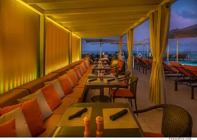 a restaurant with tables and chairs on a balcony at MVR A 5-Star Suite Feel Without Leaving the Grove in Miami