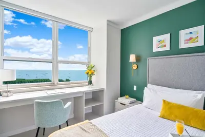 a bedroom with a bed and a desk and a window at MVR Biscayne Bay Views That Stun Daily in Miami
