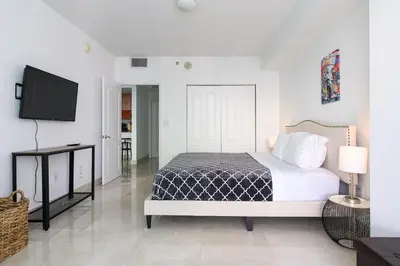 a bedroom with a bed and a flat screen tv at Spacious Penthouse in Brickell 3 BR, Free Parking in Miami