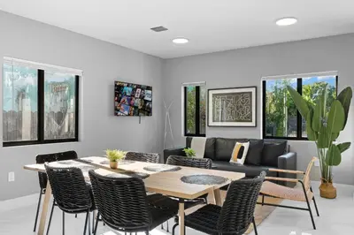 a dining room with a table and chairs and a couch at Spacious 4-BR House W Free Parking in Miami
