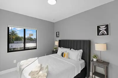 a bedroom with a large white bed with a window at Spacious 4-BR House W Free Parking in Miami