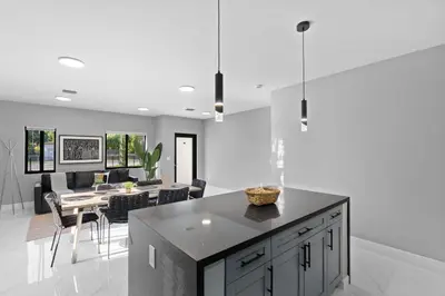 a kitchen and living room with a table and chairs at Spacious 4-BR House W Free Parking in Miami